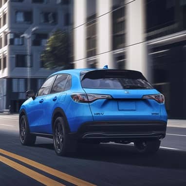 2027 Honda HR-V Sport in Boost Blue Pearl three quarter rear view driving through the city (Subcompact Crossover SUV).