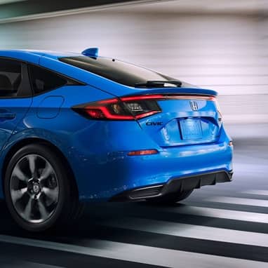 2027 Honda Civic Hatchback tSport Touring Hybrid in Boost Blue Pearl back driving through a tunnel (Compact Hatchback).
